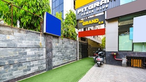Un estrecho callejón con un sendero empedrado, una pared de piedra y una zona de césped artificial verde.
