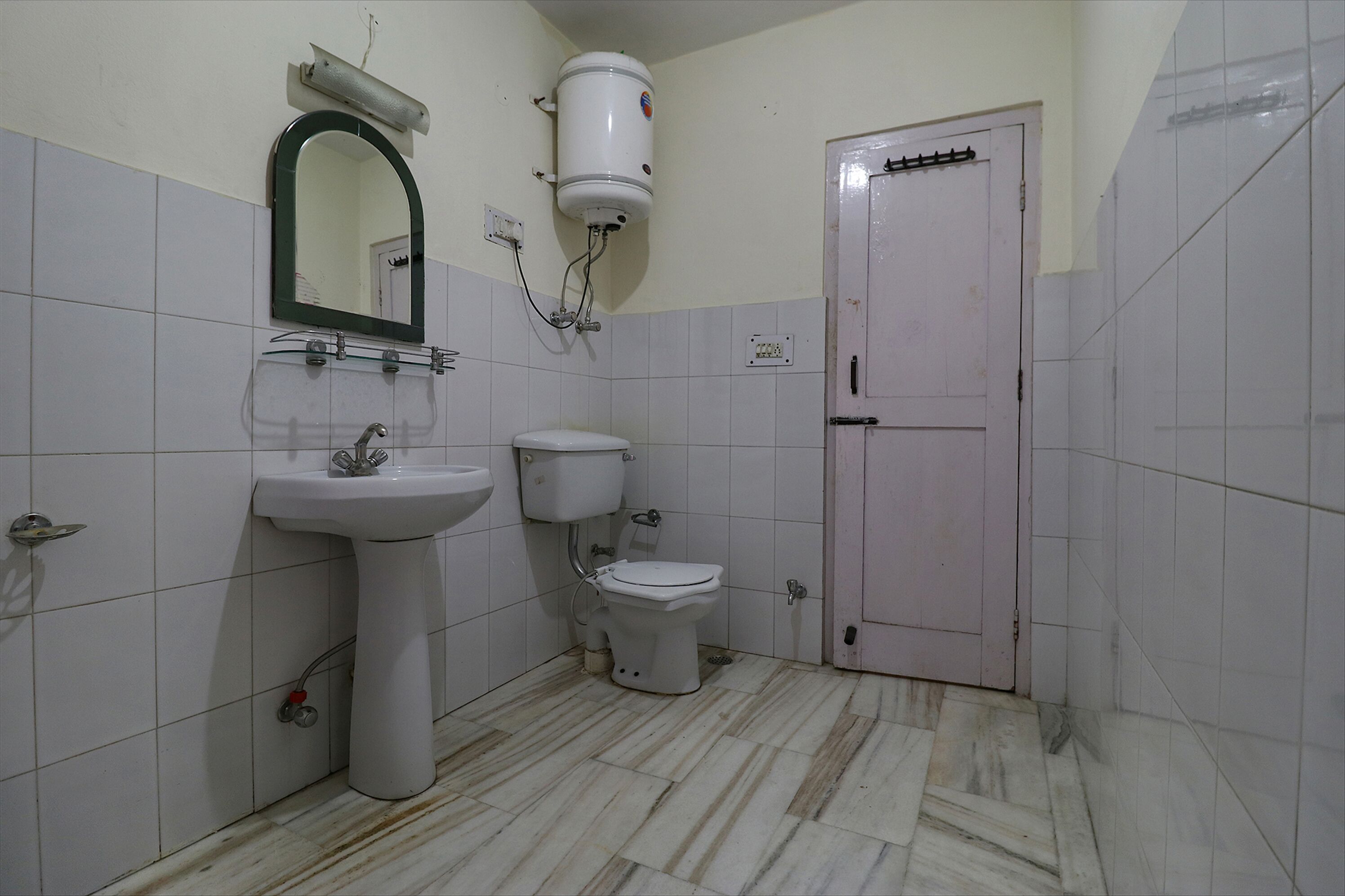 A bathroom with a sink, toilet, and a water heater.