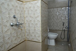 A bathroom with a toilet, a shower, and a sink with a faucet. - Fabhotel Golden Bliss (Bhubaneshwar)