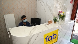 A hotel reception desk with a marble counter, a computer, and a sign reading "fab hotels". - Fabhotel Golden Bliss (Bhubaneshwar)