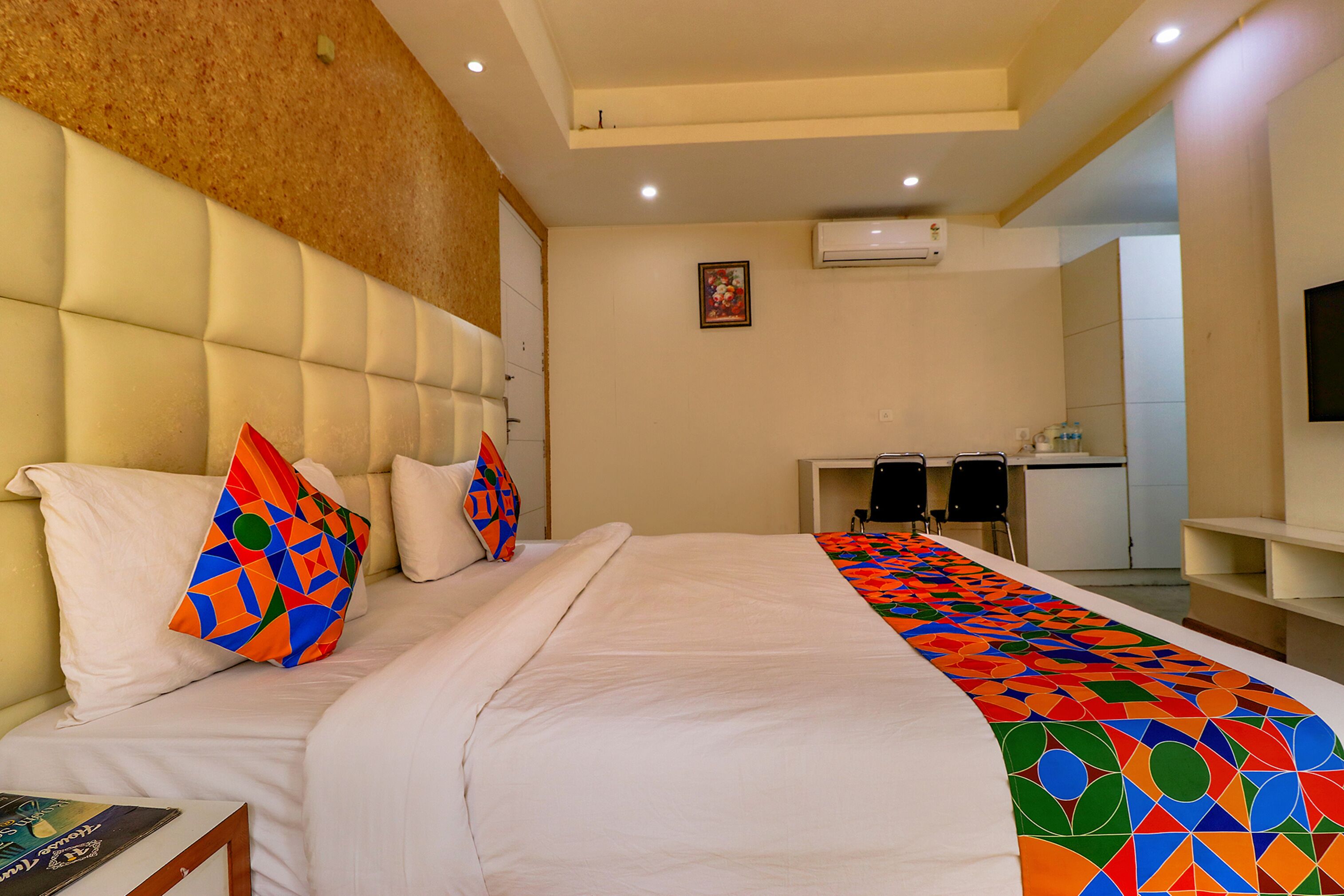 Una habitación de hotel con cama, escritorio y televisión.