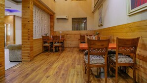 Interior de madera con zona de comedor, ventilador de techo y equipo de aire acondicionado.