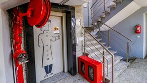 Un hidrante, una puerta con alguien dibujando, y una escalera con un extintor.
