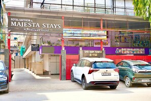 A hotel entrance with a sign for 'Majesta Stays' and a children's play area in the background.