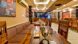 Un restaurante con muebles de madera, una larga mesa de comedor y un ventilador de techo.