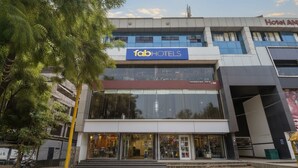 Un edificio moderno con el cartel 'fabHOTELS', con fachada de vidrio y entrada visible.