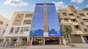 Un hotel con fachada de vidrio moderna, un letrero que dice 'Hotel Royal Inn' y un letrero de 'fabHOTELS'.