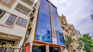 Un hotel con fachada de vidrio moderna, varios balcones y un cartel que indica que es un hotel.