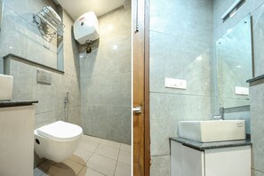 A bathroom with a toilet, a sink, a shower, and a mirror. - Fabhotel Melano (Dera Bassi)