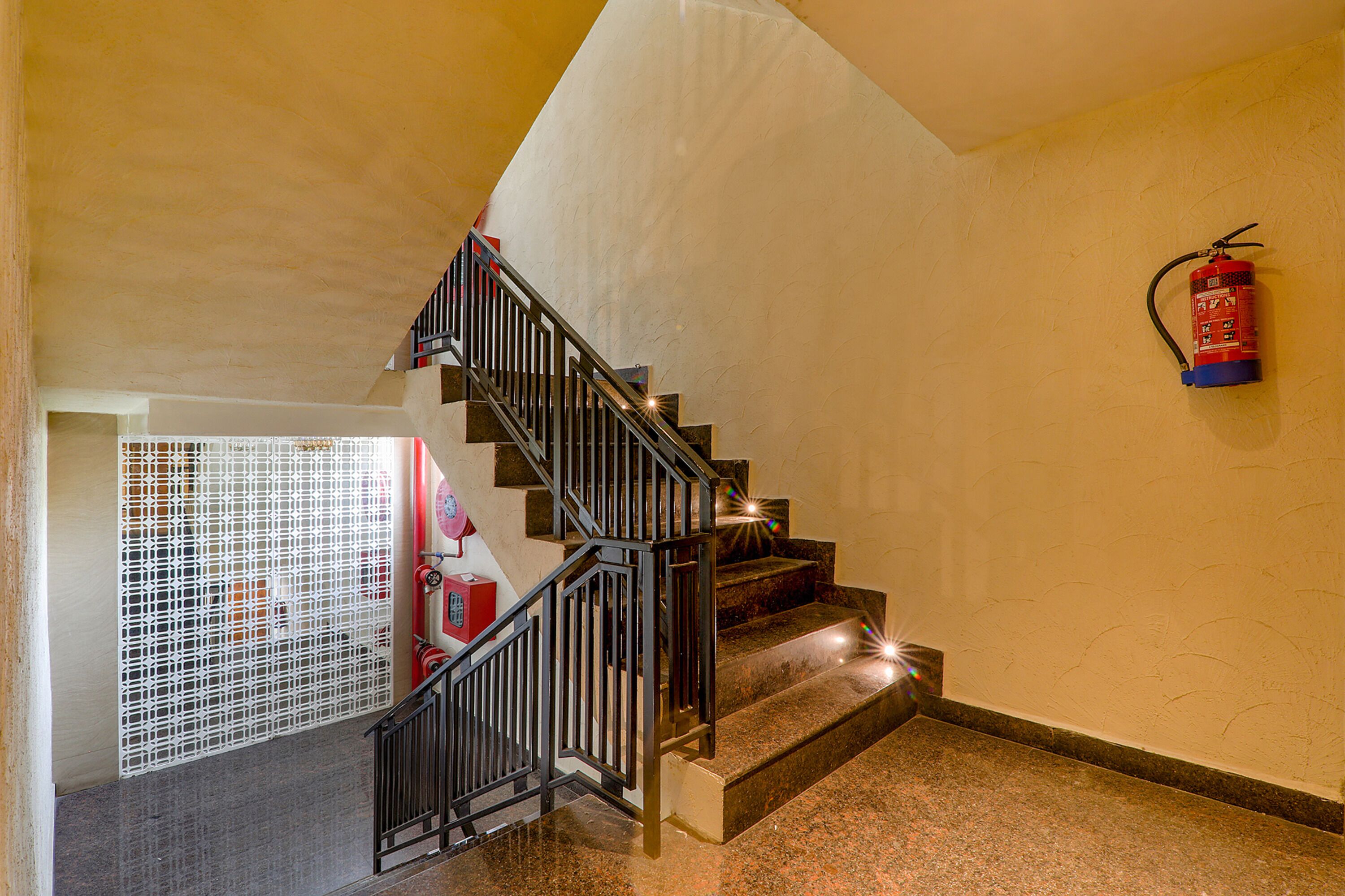 A staircase with a fire extinguisher mounted on the wall.