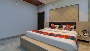 A modern bedroom with a large bed, wooden headboard, and a ceiling with a wooden panel design. - FabHotel Super 3 Premium - 800m from Kashi Vishwanath Temple (Varanasi)