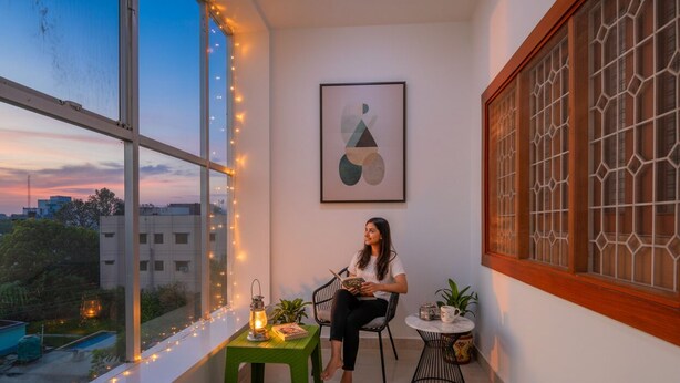 A room with a large window, a small table with a lantern, and a chair. - FabHotel Super 3 Premium - 800m from Kashi Vishwanath Temple (Varanasi)
