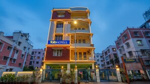 A multi-story hotel with a prominent 'fabHOTELS' sign, a gated entrance, and a well-lit facade. - Fabhotel Capital Casa (Barasat)