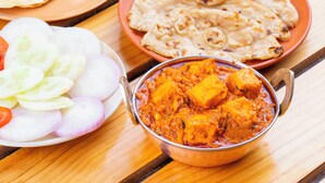 A meal with paneer curry, naan bread, and a side salad. - Fabhotel Anutham (New Delhi)