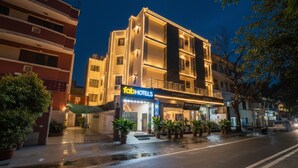A hotel with a modern facade, a visible entrance, and potted plants in front. - Fabhotel Anutham (New Delhi)