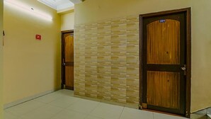 Un pasillo con dos puertas de madera, una con el número 201, y una pared con textura.