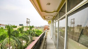 A balcony with a view of greenery and buildings. - Fabhotel Kriti Green (Varanasi)