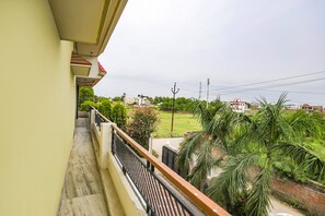 A balcony with a view of a residential area, including houses and greenery. - Fabhotel Kriti Green (Varanasi)
