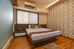 Un dormitorio con cama de madera, mesita de noche, cajón, ventana con persianas y papel tapiz estampado.