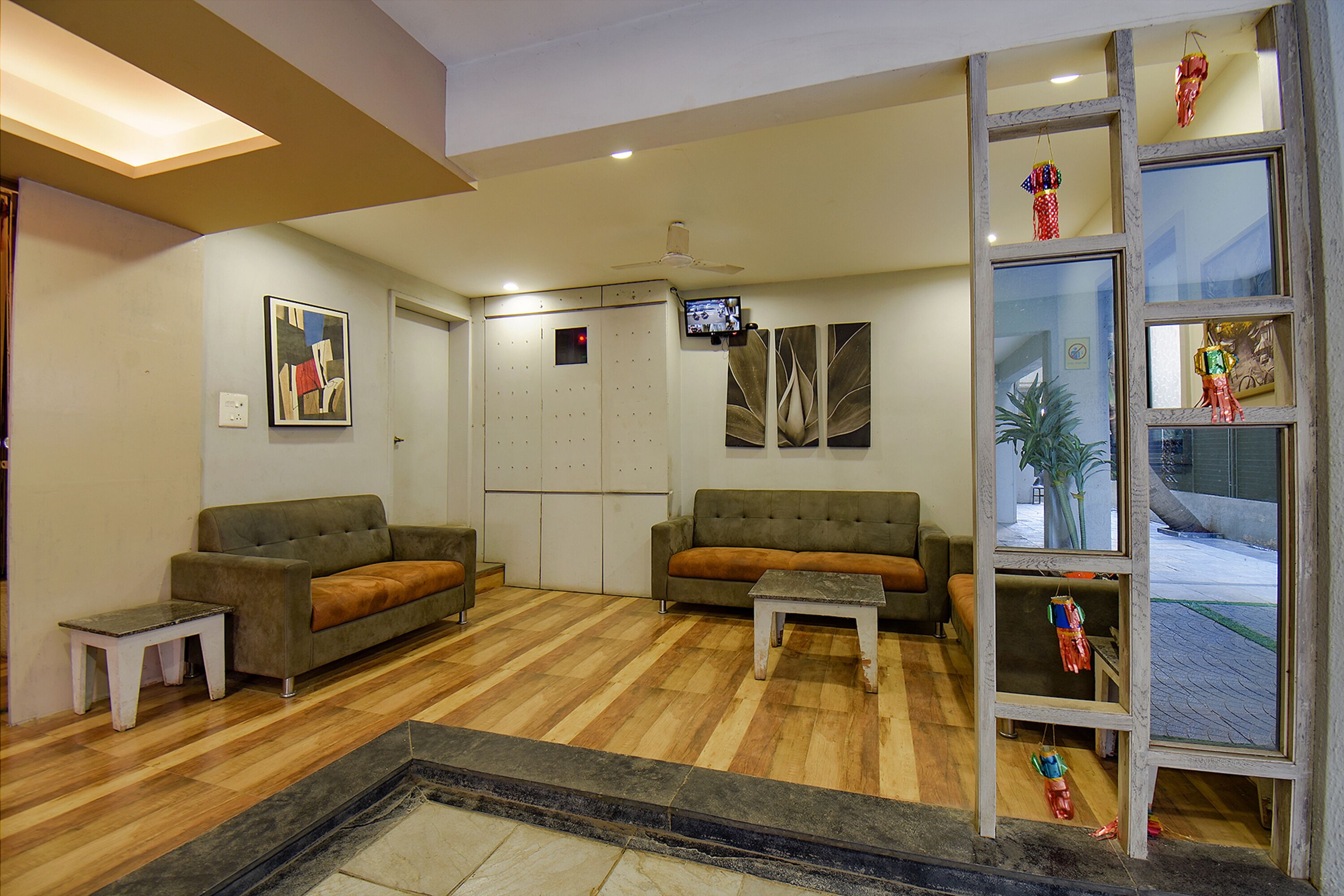 A living room with two sofas, a coffee table, a small table, and a TV mounted on the wall.