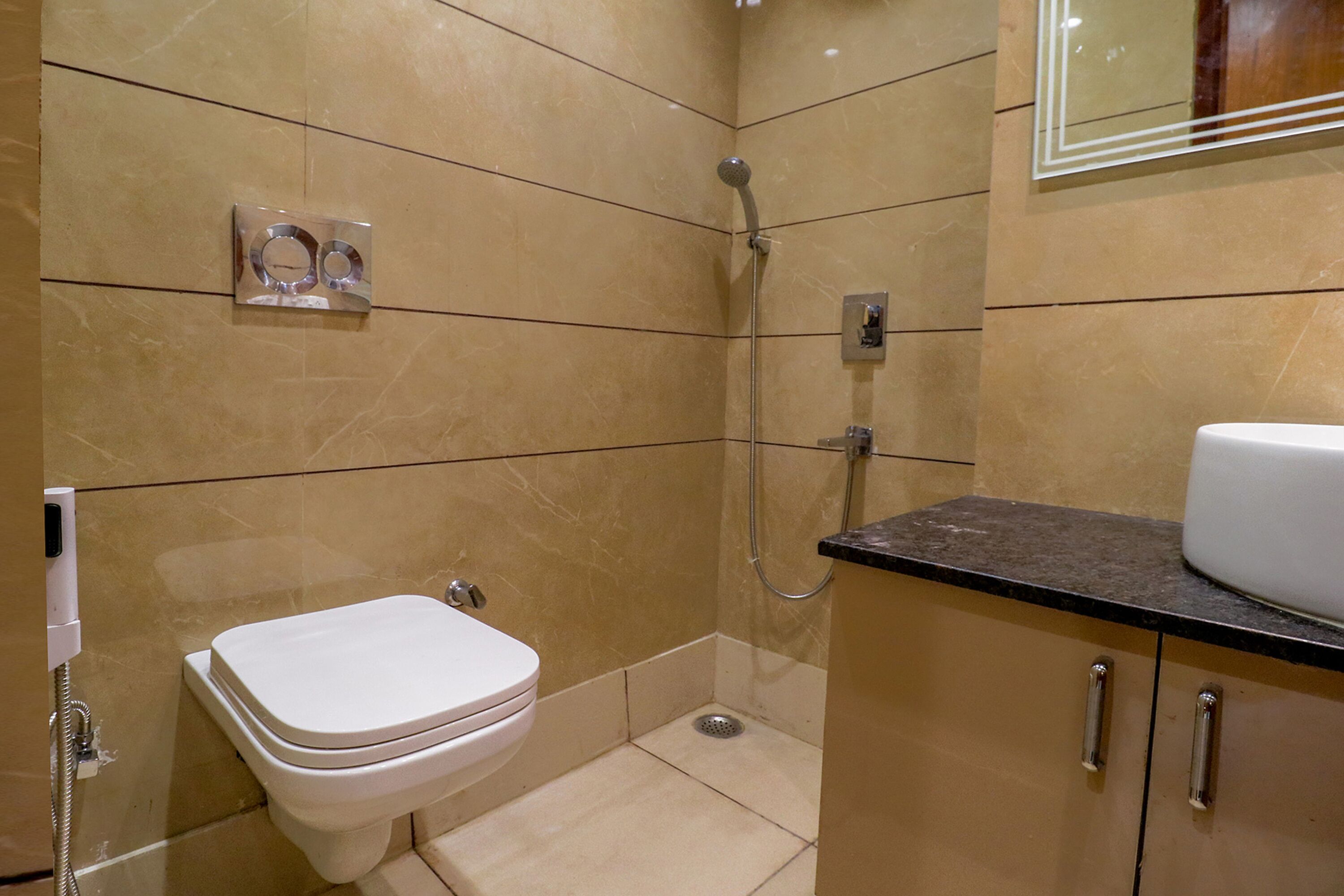 A bathroom with a toilet, a shower, and a sink.