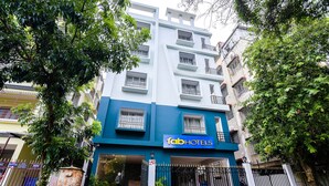 A multi-story building with a blue and white facade, a sign for 'Fab Hotels', and a gated entrance. - Fabhotel Eden (Baruipur)