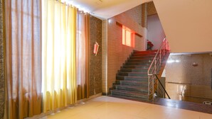 A staircase with a red handrail leading to an upper floor. - Fabhotel Gold Galaxy (Kanpur)