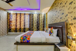 A hotel room with a bed, curtains, a telephone, and a wall with a geometric pattern. - Fabhotel Gold Galaxy (Kanpur)