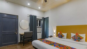 A hotel room with a bed, a desk, a chair, a round mirror, and a window with curtains. - Fabhotel Super 3 Premium Ii (Kanpur)