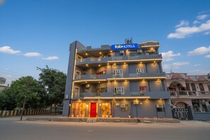 A multi-story hotel with a prominent 'fabHOTELS' sign, balconies, and a red entrance door.