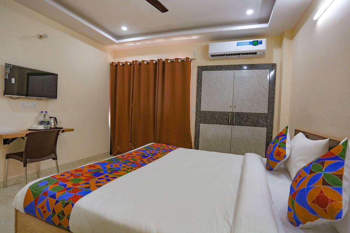 Une chambre d’hôtel équipée d’un lit, d’un bureau, d’une télévision et d’un appareil de climatisation.