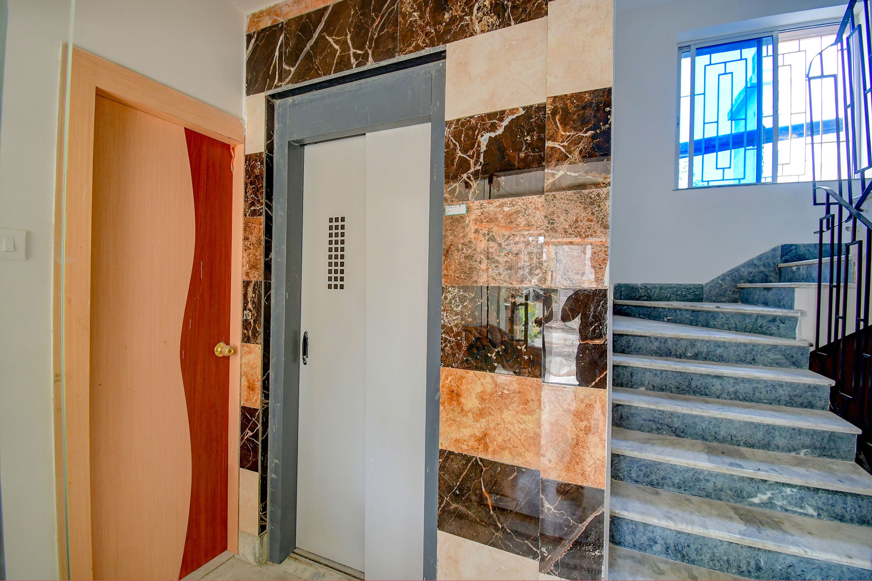 Un escalier avec des marches en marbre et une porte au design unique.