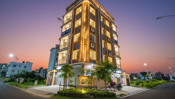 A multi-story hotel with a modern design, featuring balconies and air conditioning units on the exterior. - FabHotel Amar Raj Villa (Barasat)