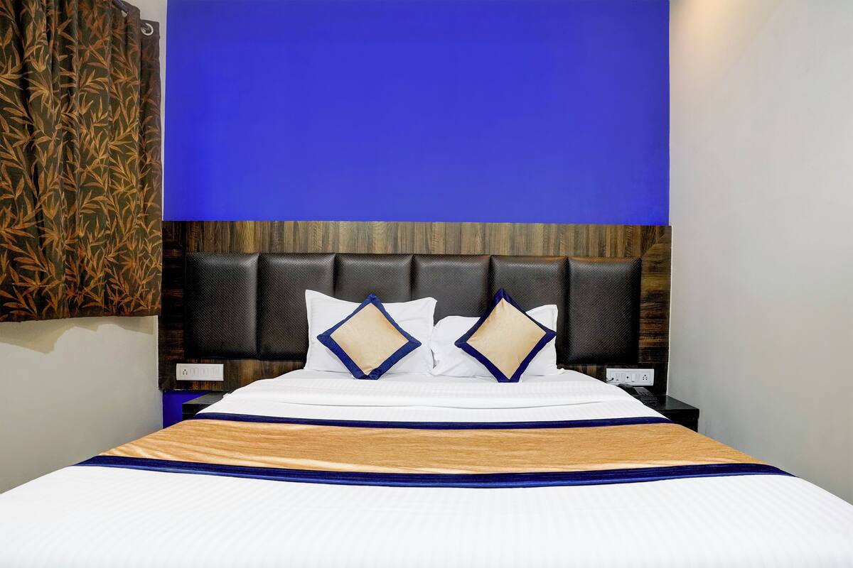 A hotel room with a bed, a headboard, and a nightstand.