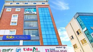Un edificio di un hotel con un cartello che indica 'Fab Hotels' e 'Udupi Hotels'.