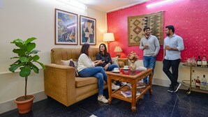 A living room with a sofa, a coffee table, and a potted plant. - FabHotel Golden Imperial (Kolkata)