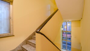 A staircase with a handrail, a window with blinds, and a door with a measurement scale. - FabHotel Golden Imperial (Kolkata)