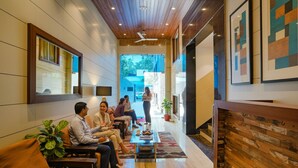 A modern interior with a long corridor, wooden ceiling, and a seating area with sofas and a coffee table.
