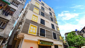 A multi-story building with a sign for 'Binoy Krishna Bhawan' at the ground level, indicating it is a hotel. - Fabhotel Luxury Stay (Bidhannagar)