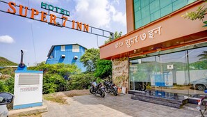A hotel entrance with a sign reading "HOTEL SUPER7 INN" and a blue building in the background. - Fabexpress Super 7 Inn (Navi Mumbai)
