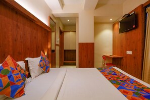 A hotel room with a bed, a desk, and a television on the wall. - Fabexpress Super 7 Inn (Navi Mumbai)