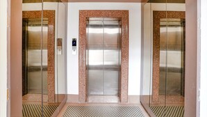 An elevator with a metallic interior and a granite border. - Fabhotel Gargi Deluxe (Pune)