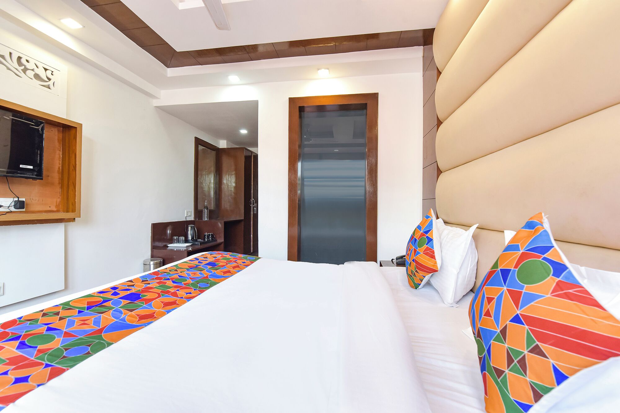 Een hotelkamer met een bed, een bureau, een spiegel en een lift.