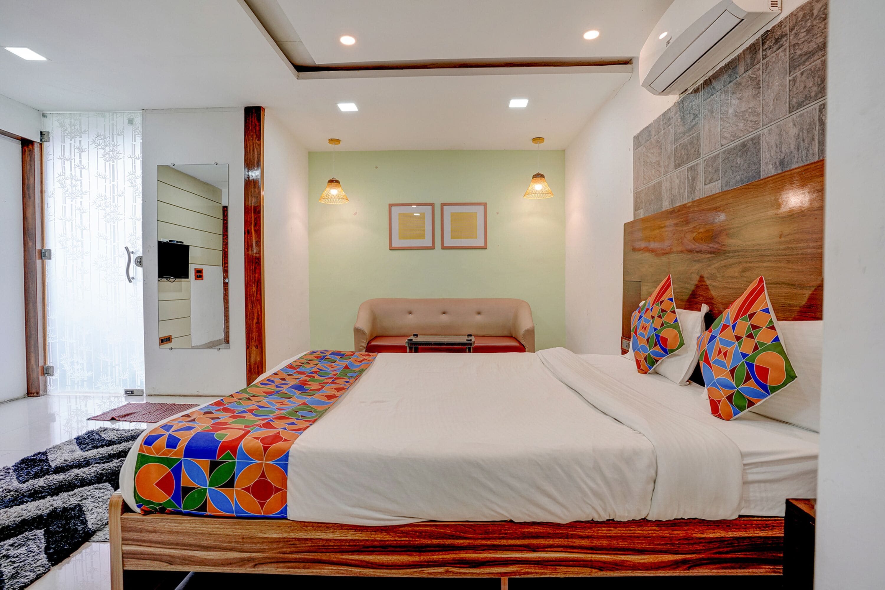 A modern bedroom with a large bed, a wooden headboard, and a colorful throw blanket.