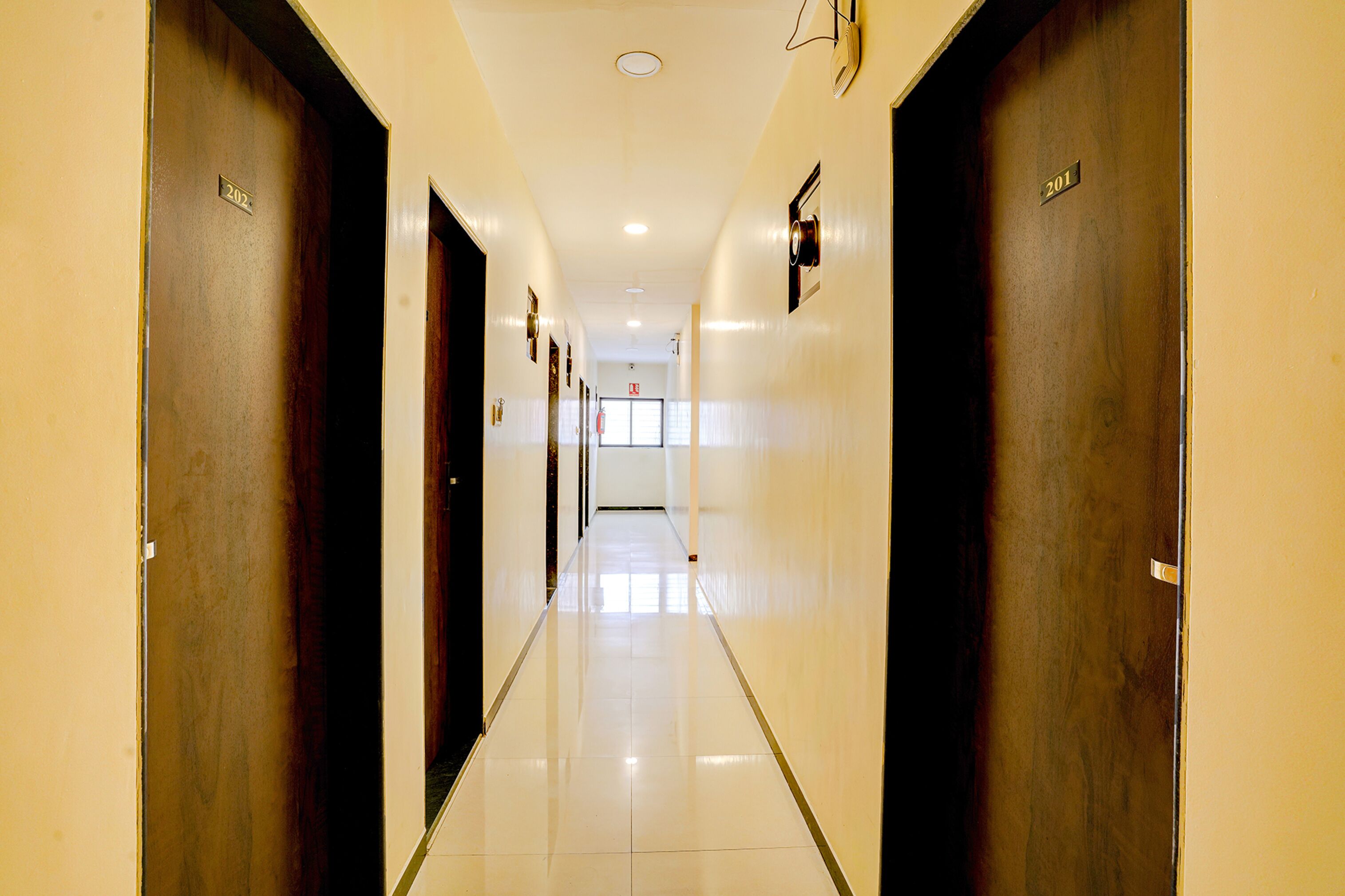 A hotel hallway with doors numbered 201 and 202, leading to rooms.