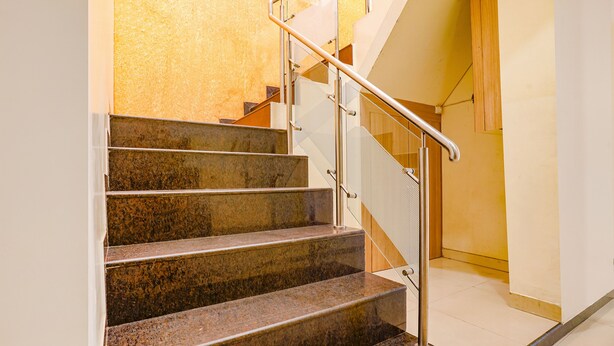 Um conjunto de degraus de granito com corrimão de metal que levam a um patamar.