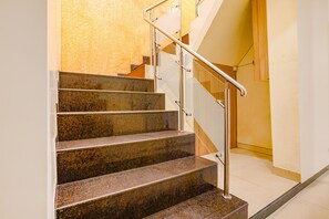 Eine Treppe aus Granit mit Metallgeländer, die zu einer Plattform führt.