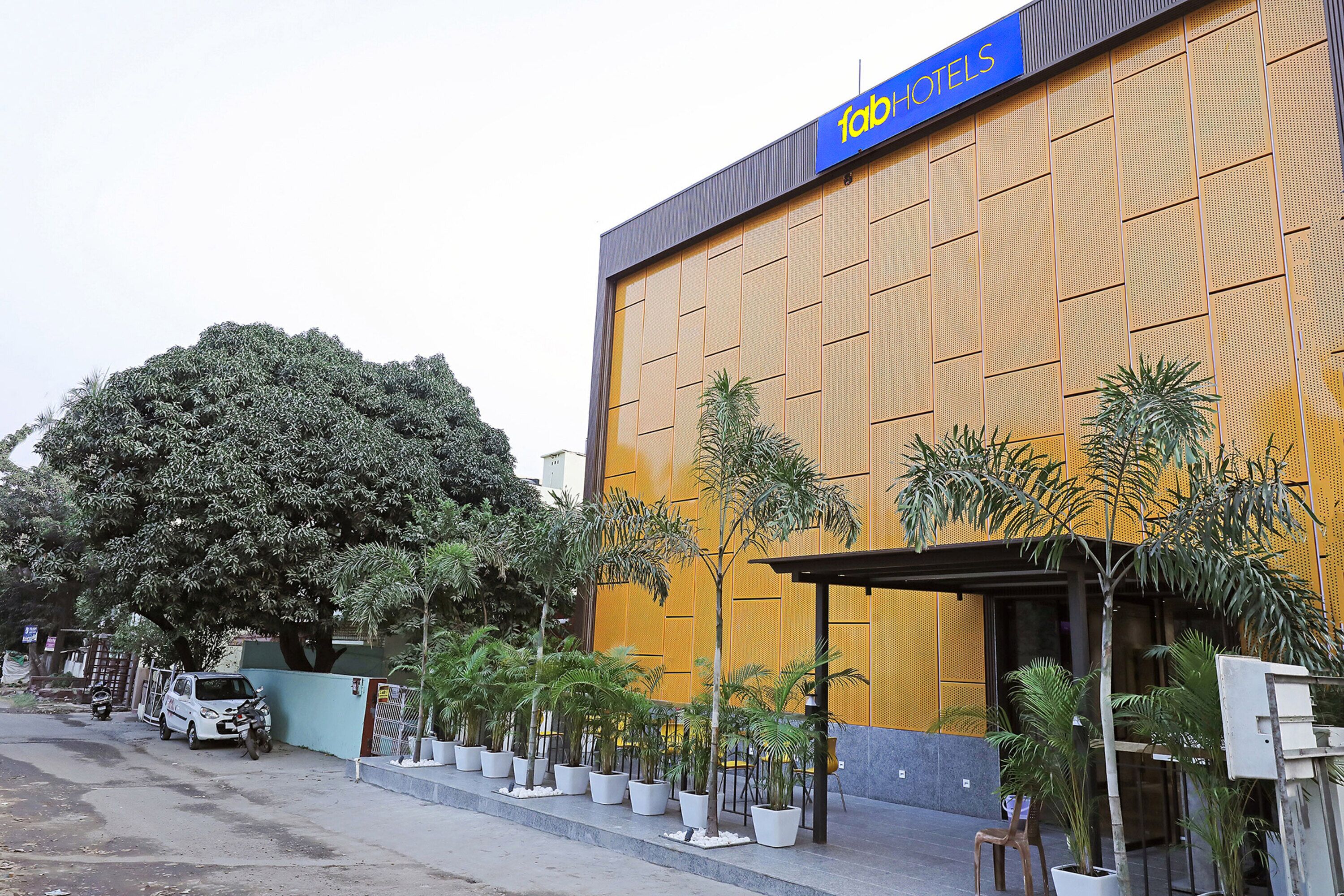 Un hotel con un letrero grande que dice “HOTELS” y una fachada moderna con una paleta de colores azul y amarillo.