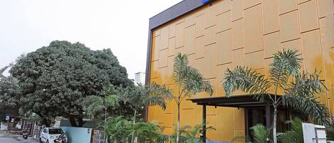 Un hotel con un letrero grande que dice “HOTELS” y una fachada moderna con una paleta de colores azul y amarillo.