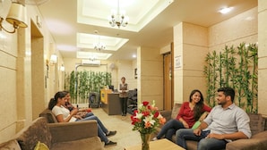 A lobby with sofas, a reception desk, and potted plants. - FabHotel Sapphire 83 Best hotel in Manesar, Gurugram (Gurugram)